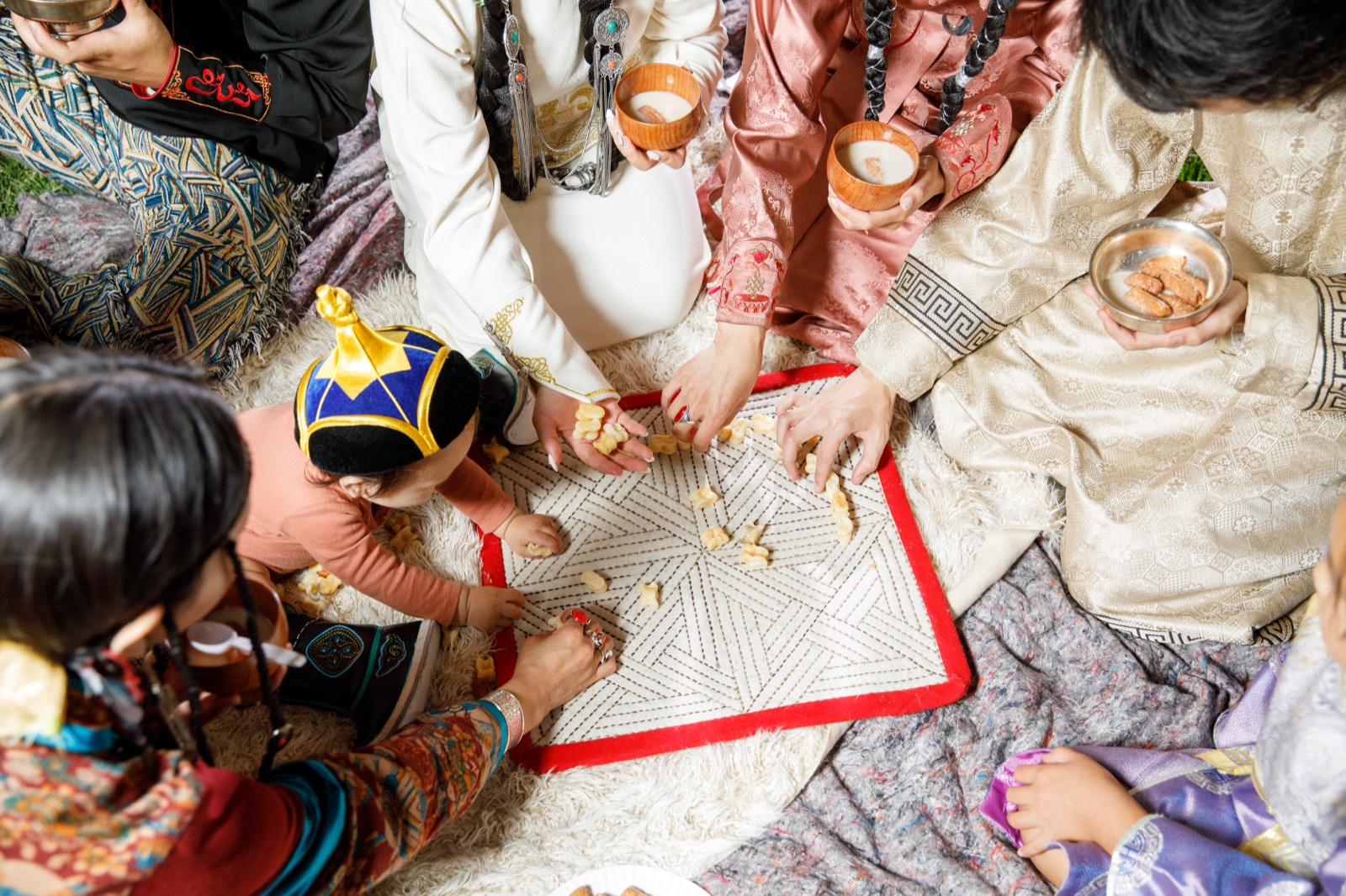 Players gathered around a mat for a game of shagai